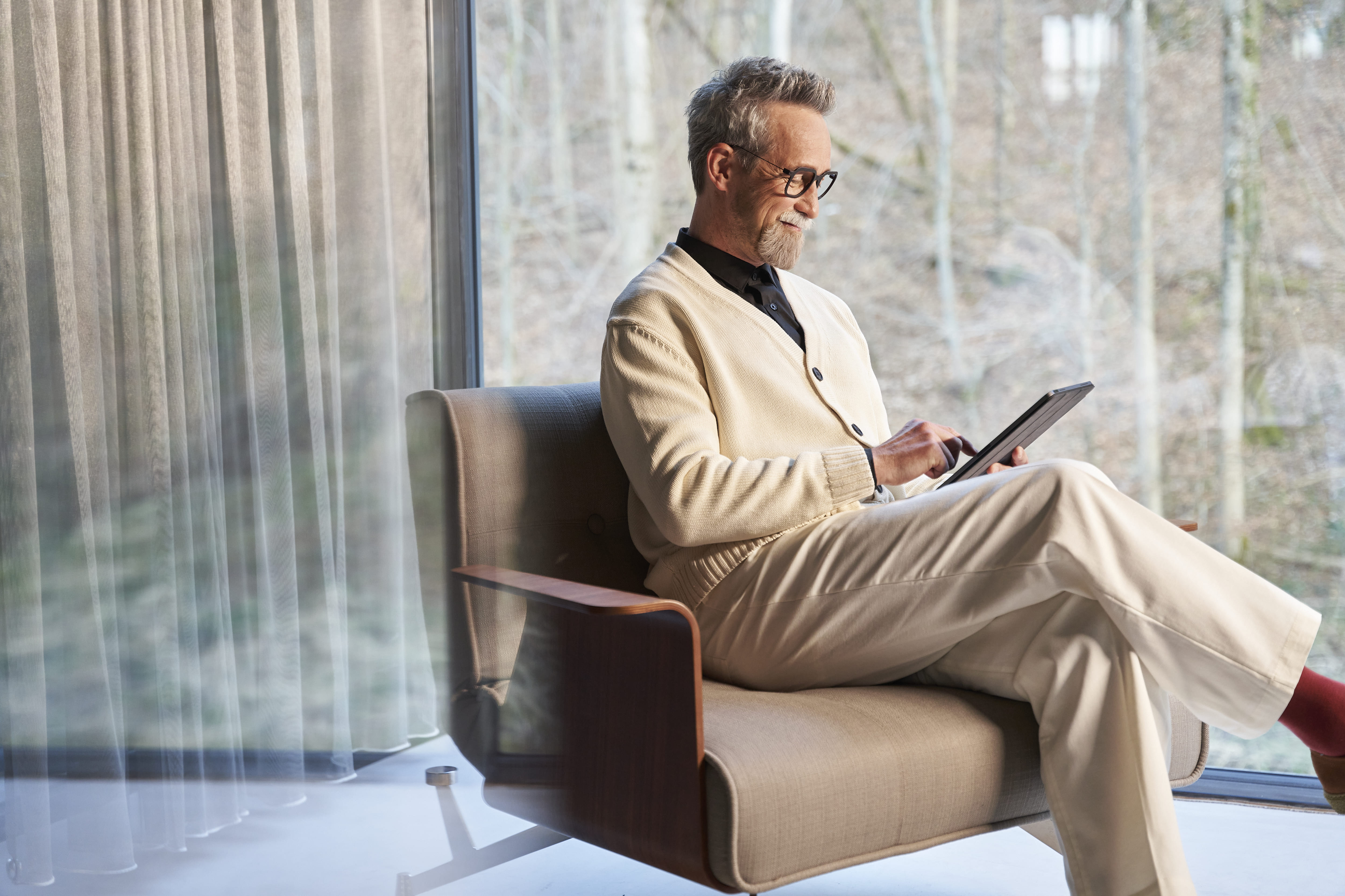 Uomo sorridente che guarda il suo tablet